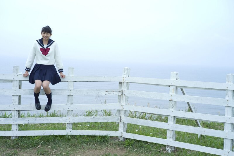 girl in school uniform by fence