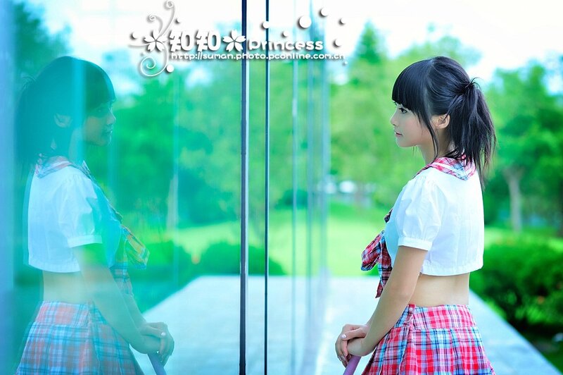 Girl in school uniform by glass