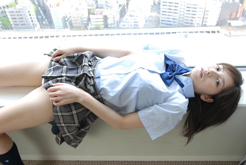 girl in school uniform lying on window