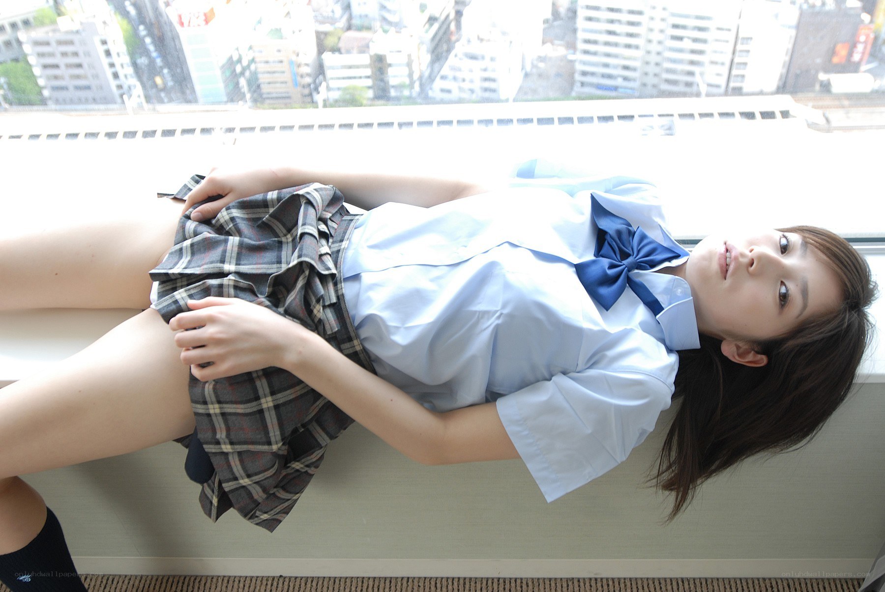 girl in school uniform lying on window
