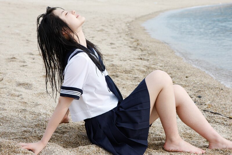 Girl in school uniform on beach