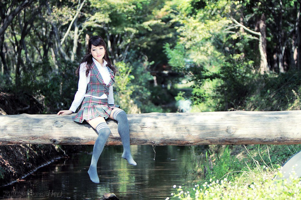 Girl in school uniform on log