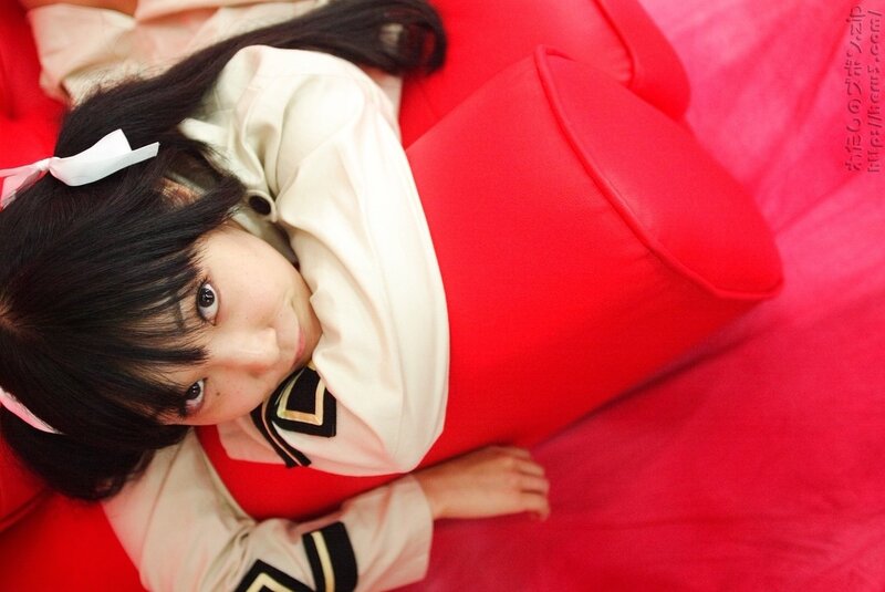 girl in school uniform on red couch
