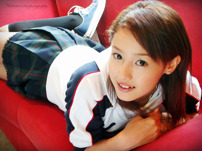 girl in school uniform on red couch