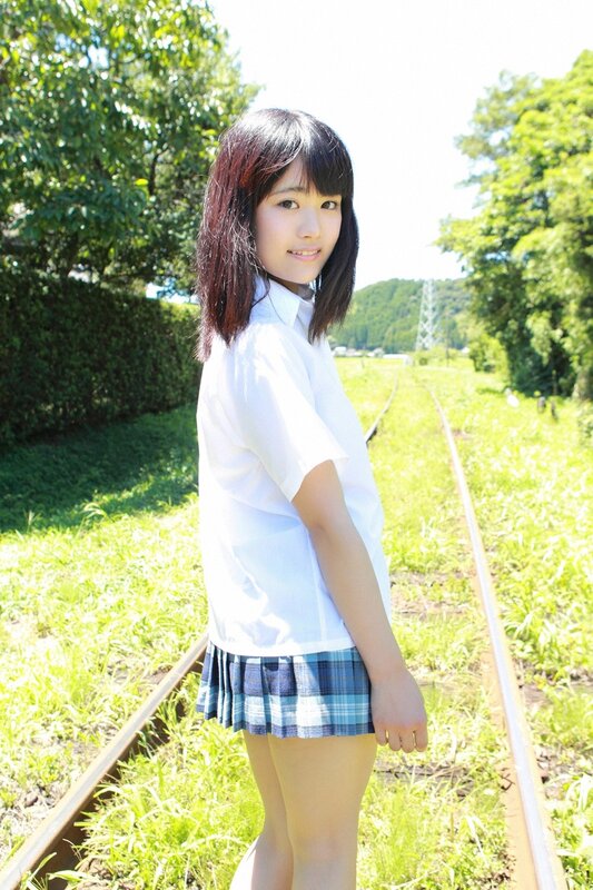 Girl in school uniform on train tracks