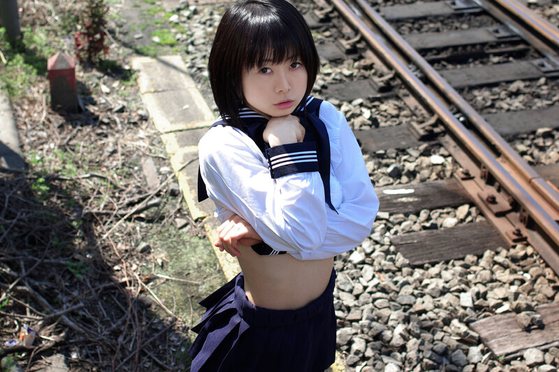 girl in school uniform on train tracks