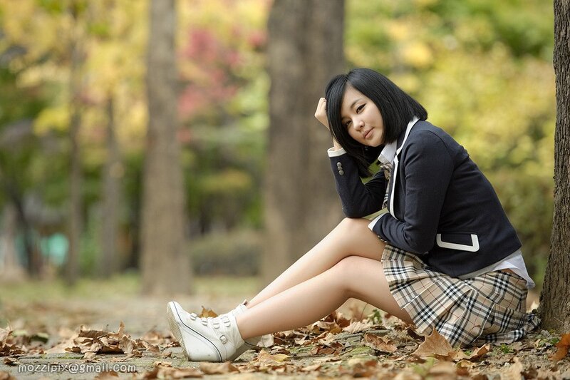 Girl in school uniform sitting outdoors