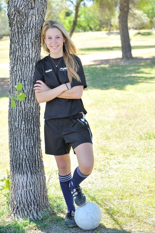 Girl in soccer uniform by tree