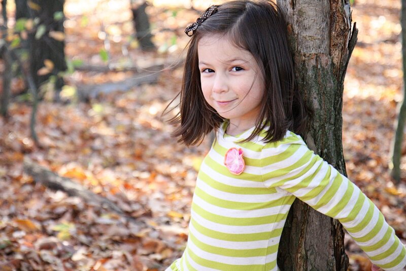 girl in striped shirt by tree