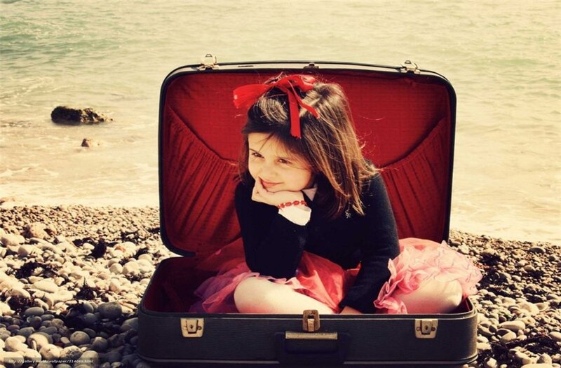 girl in suitcase at beach