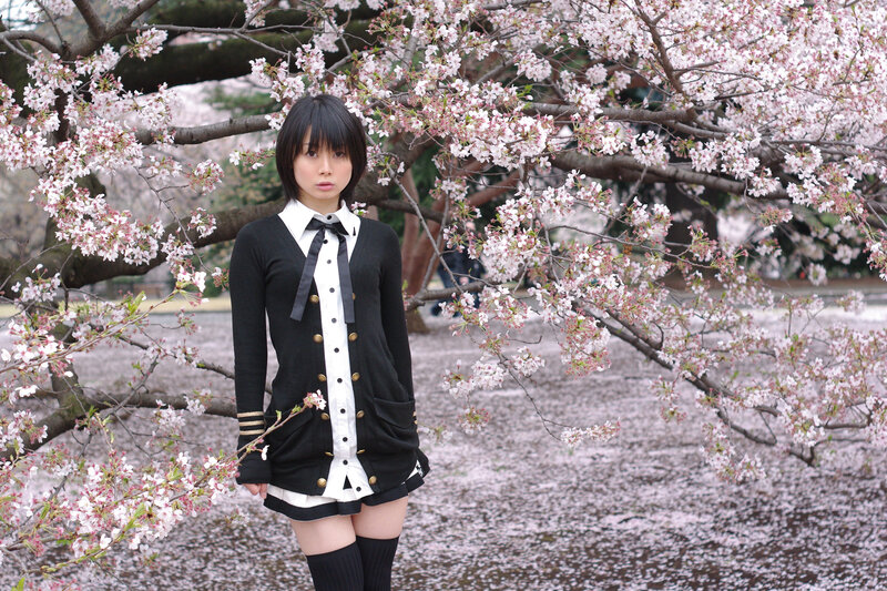 Girl in uniform under cherry blossoms