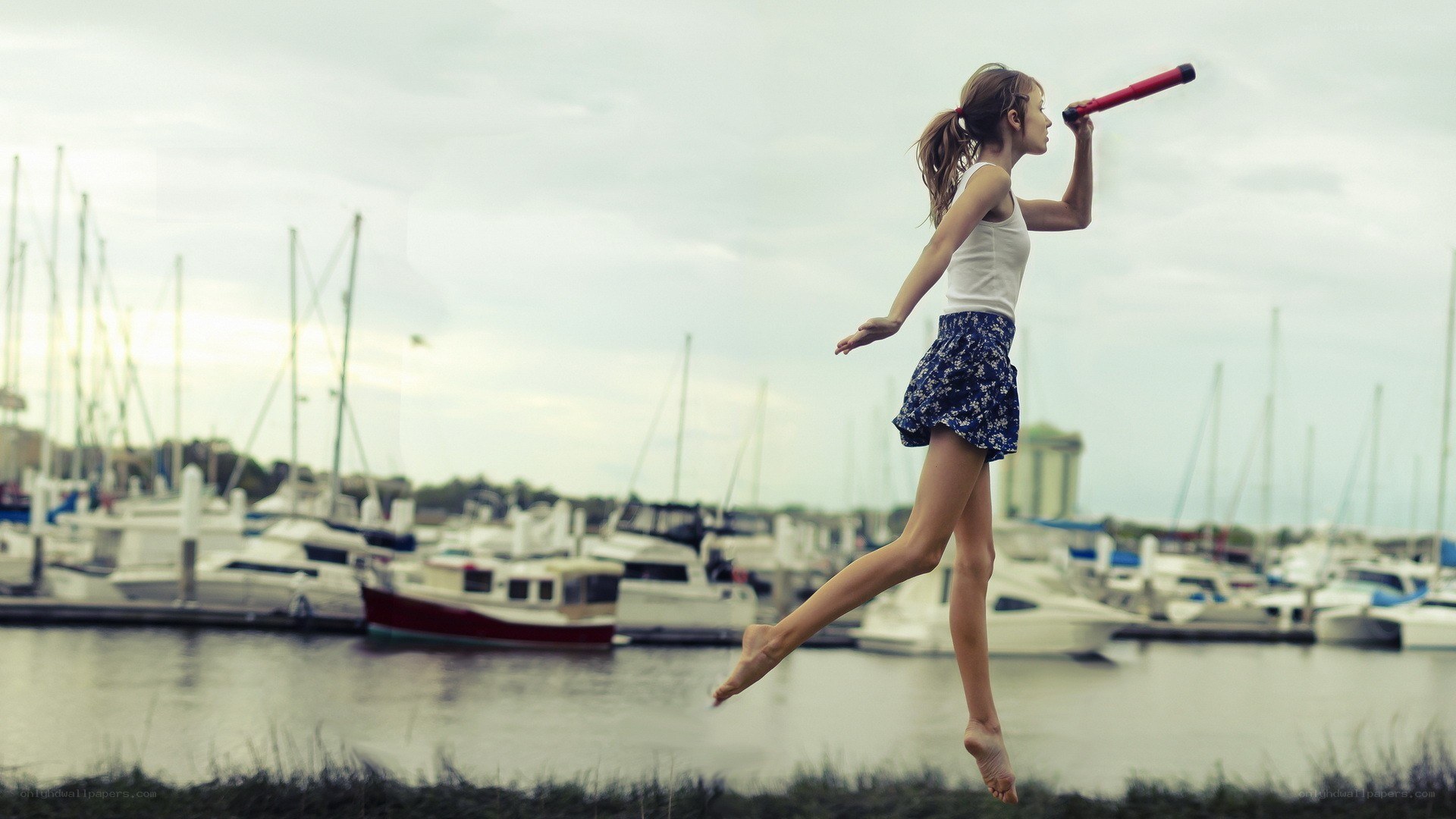 Girl jumping with toy telescope