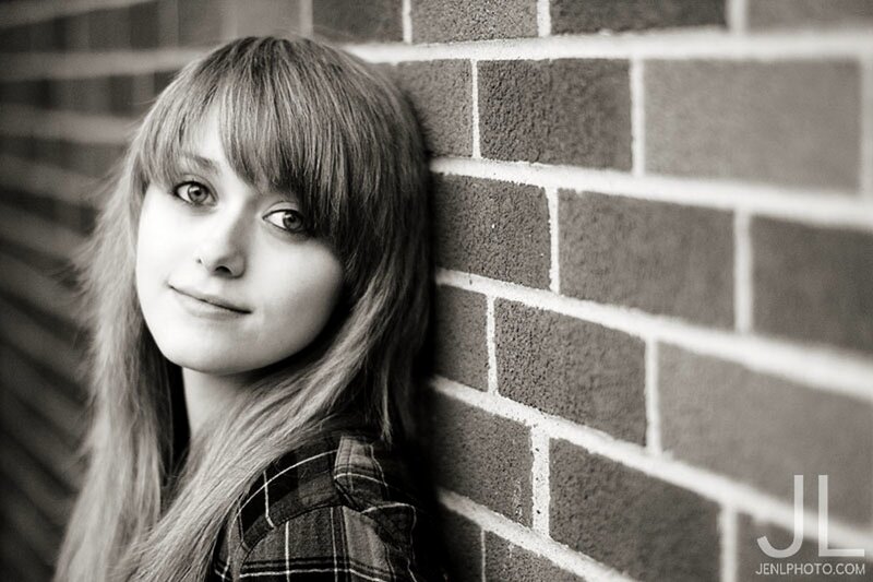 girl leaning against brick wall