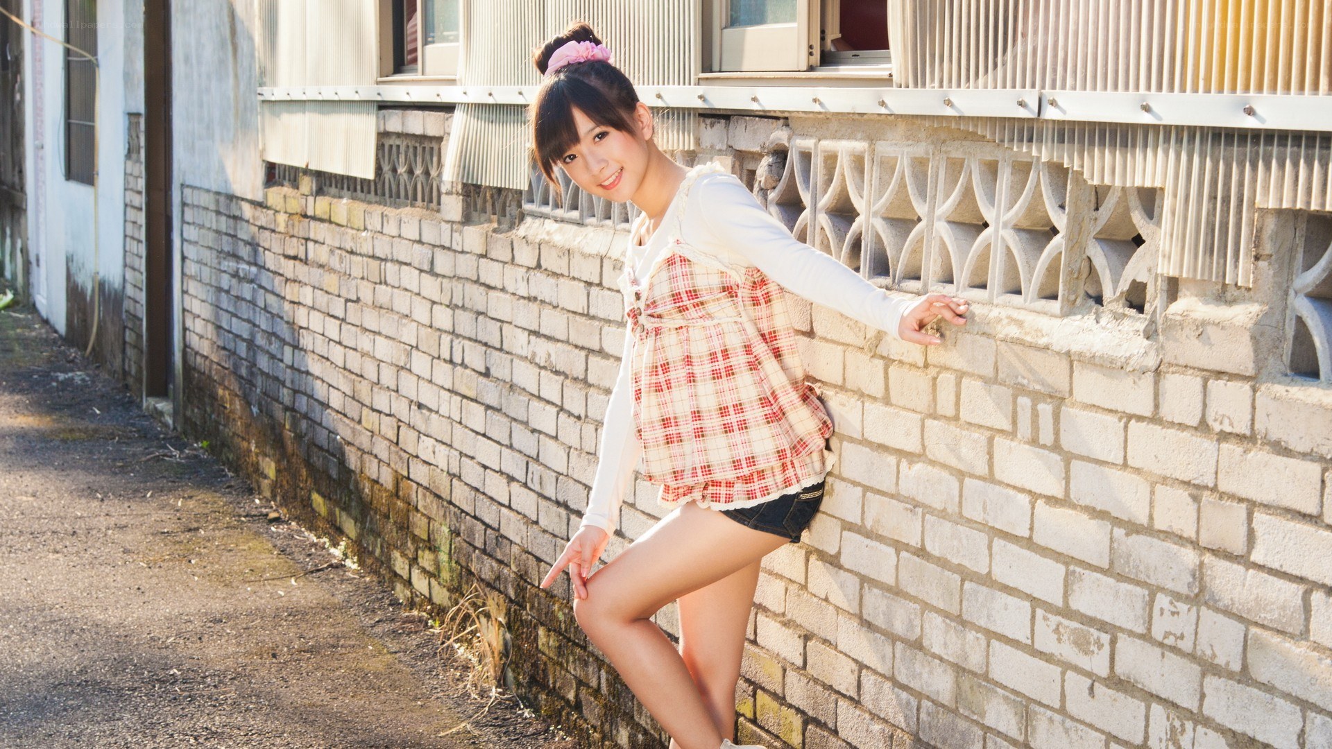 girl leaning on brick wall