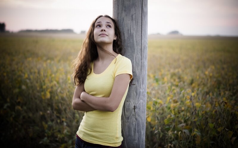 Girl Leaning on Post