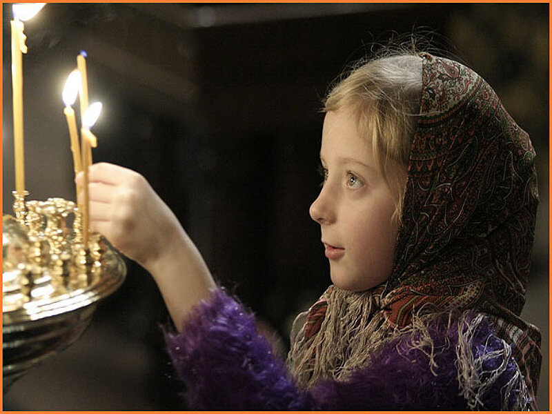 girl lighting candles in church