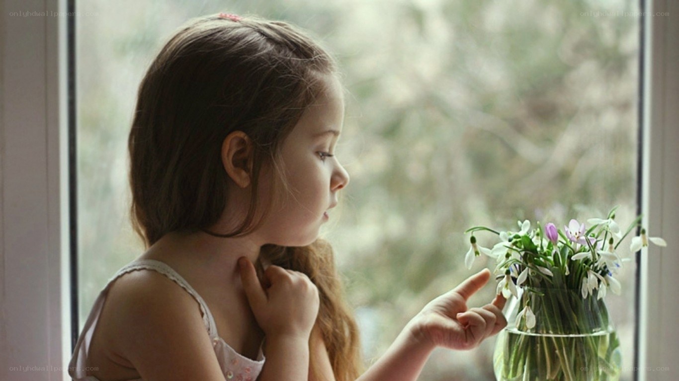 girl looking at flowers by window