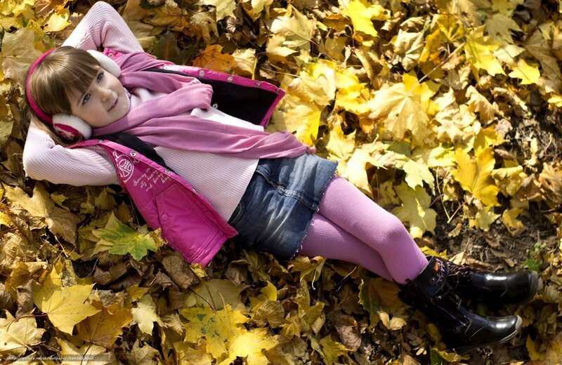 Girl lying in autumn leaves