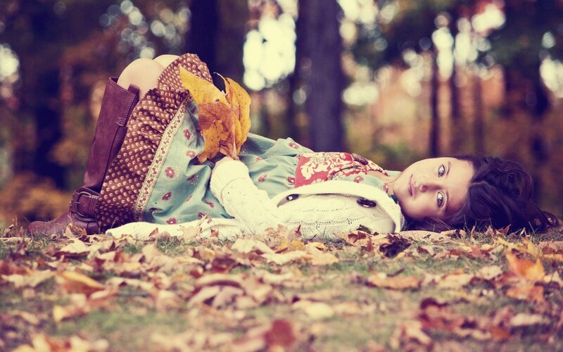 girl lying in autumn leaves