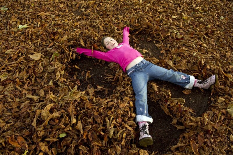 Girl Lying in Leaves — Brown
