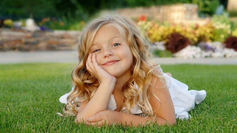 girl lying on grass smiling