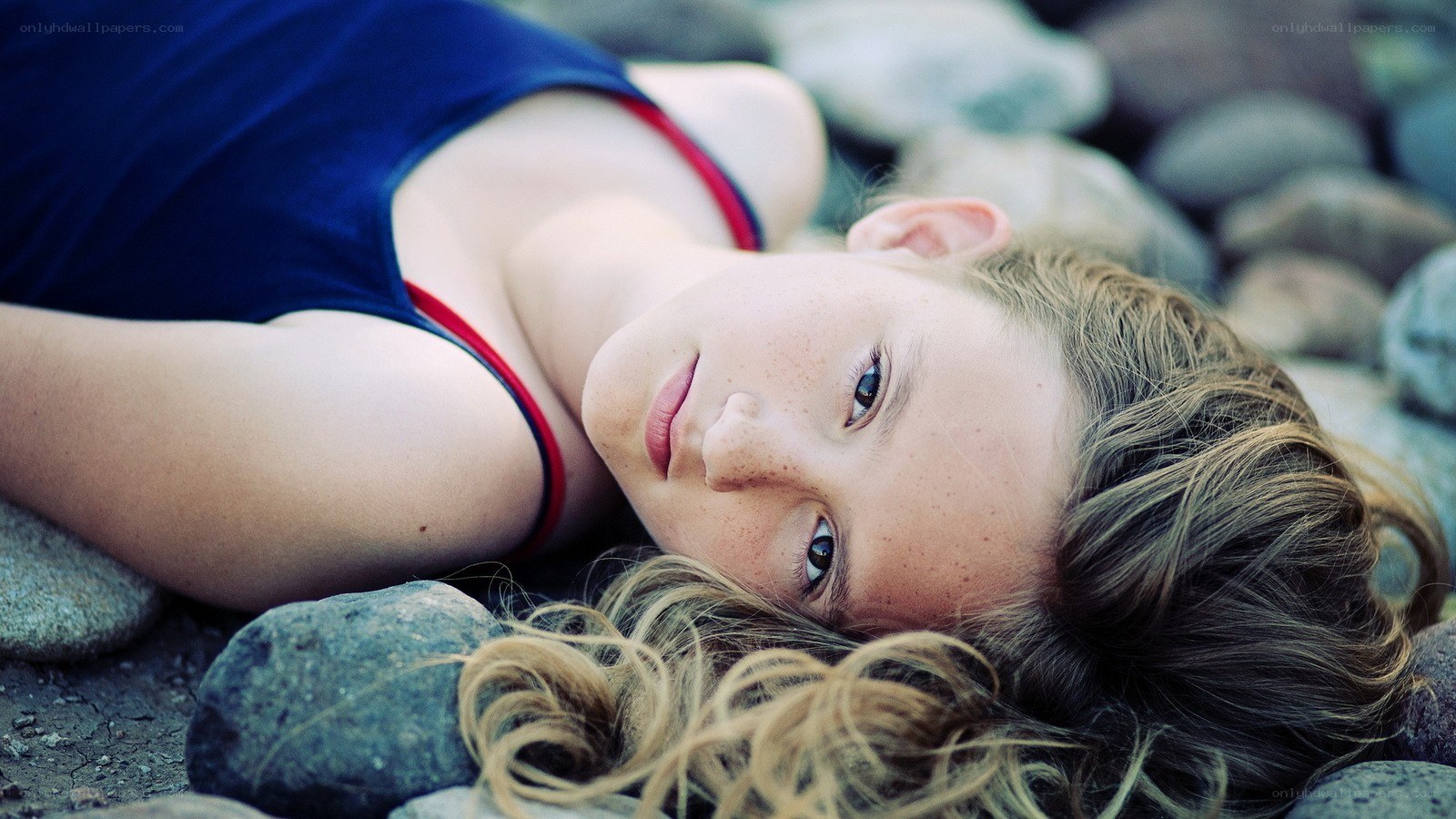 girl lying on rocks