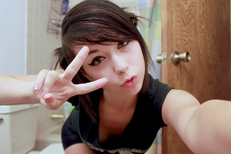girl making peace sign in bathroom
