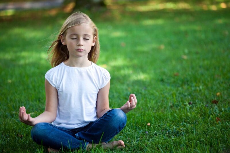 Girl Meditating on Grass