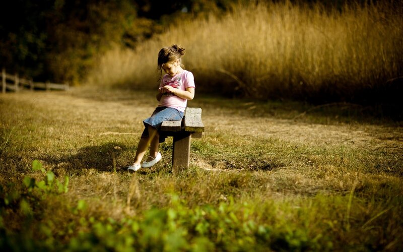 Girl on a bench in a field