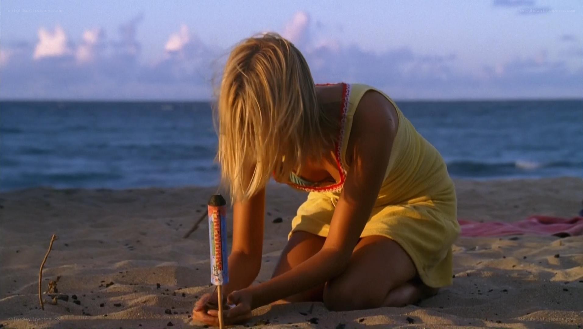 girl on beach with firework