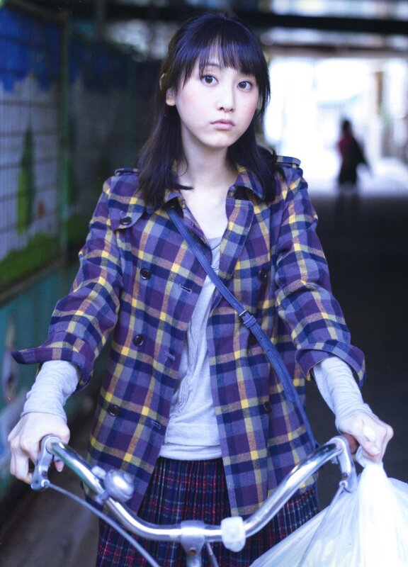 girl on bicycle in plaid jacket