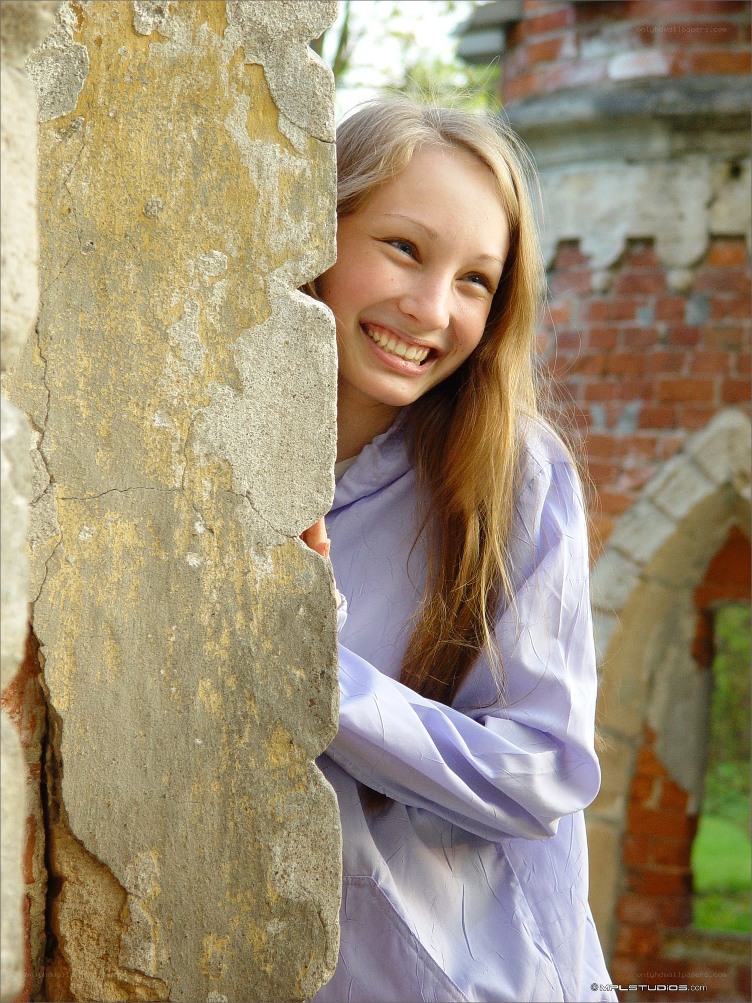 girl peeking from behind wall