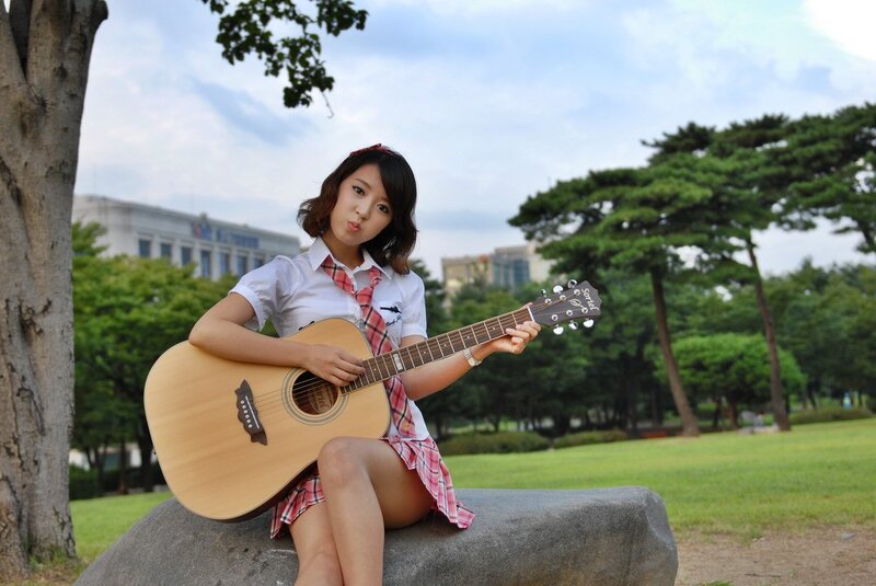 Girl playing guitar in park