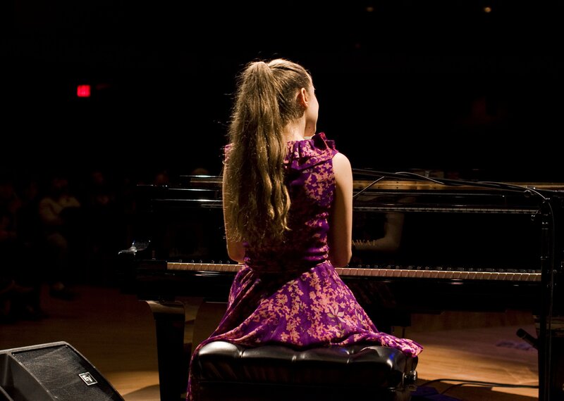 girl playing piano on stage