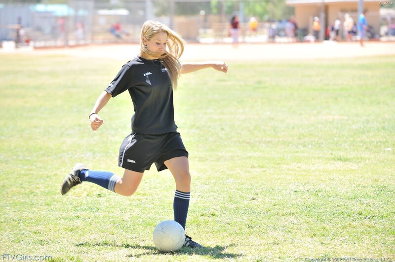 girl playing soccer on field