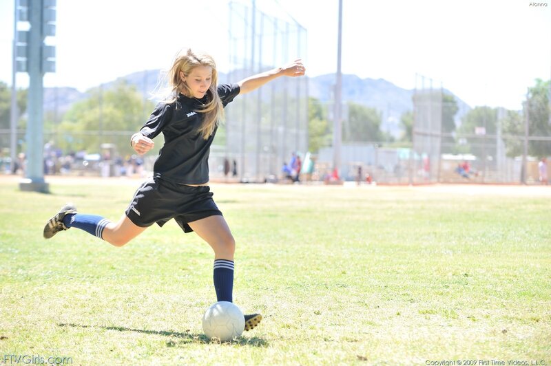 girl playing soccer on field
