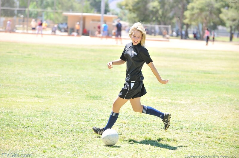 girl playing soccer on field