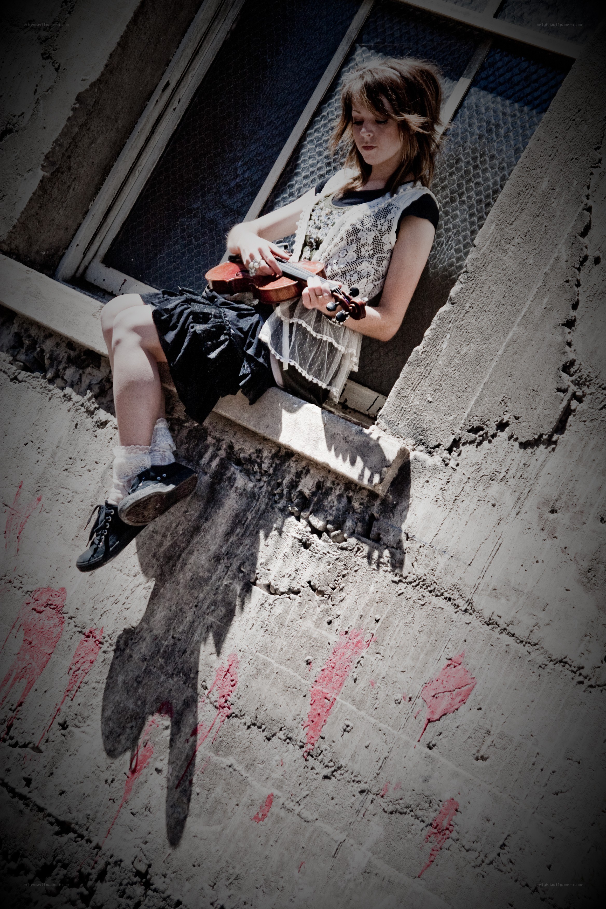 Girl playing violin on window ledge