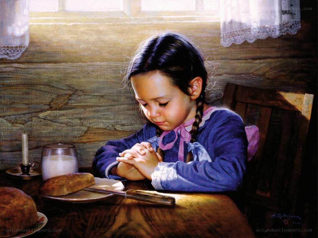girl praying at table