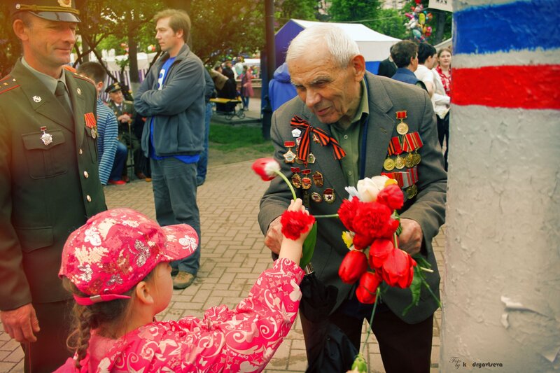 Girl presents flower to veteran