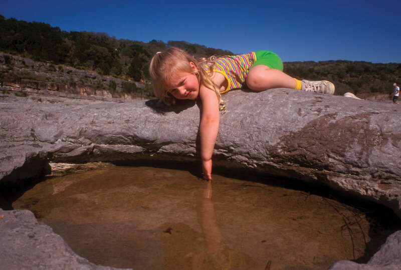 Girl Reaching into Water