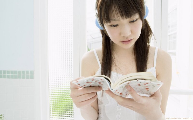 Girl reading book with headphones