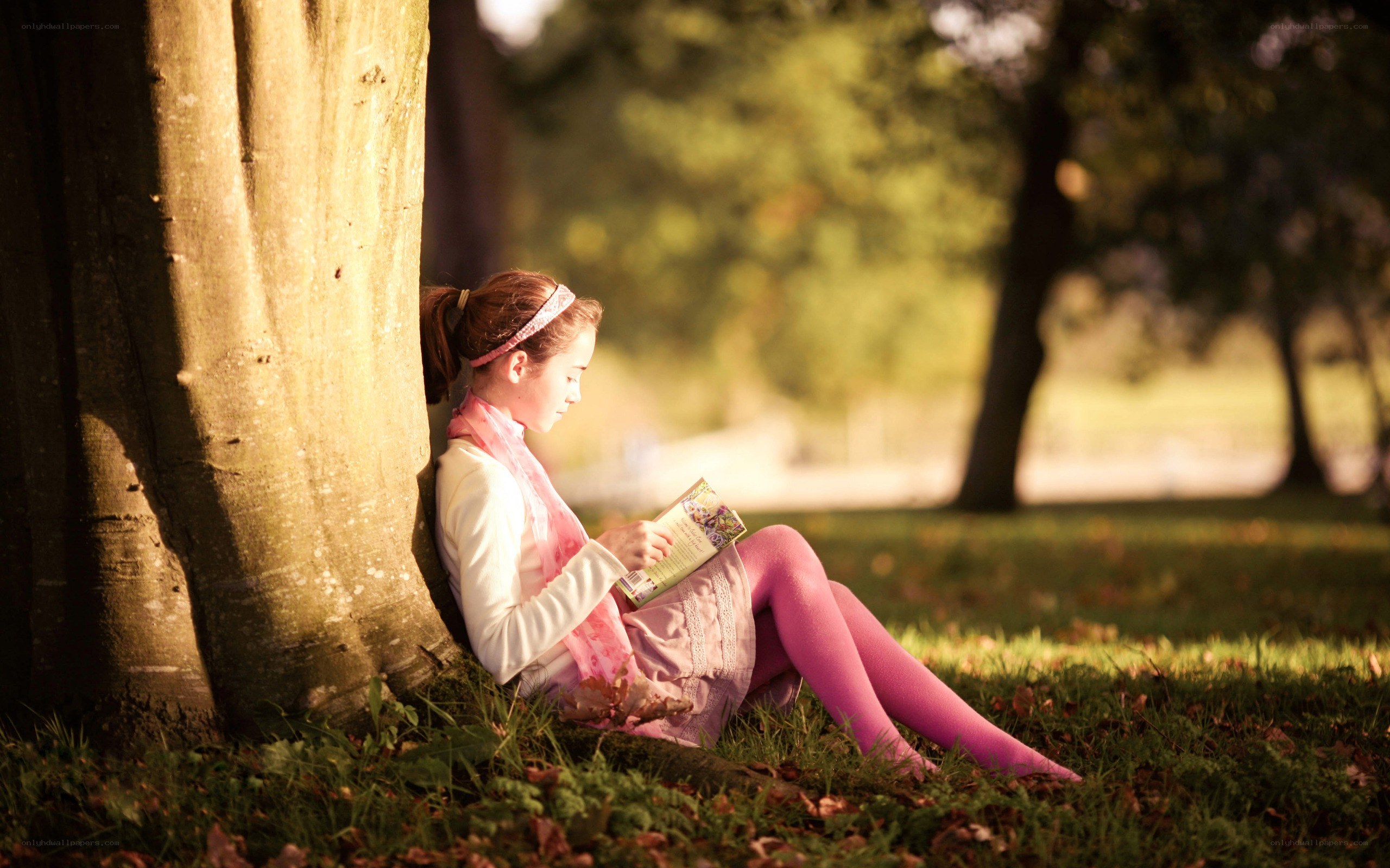 Girl reading by a tree