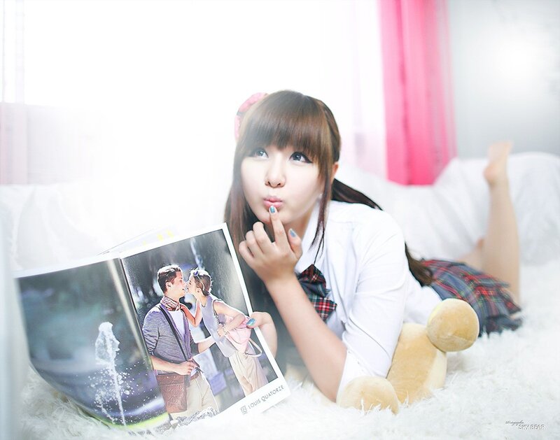 girl reading magazine on bed
