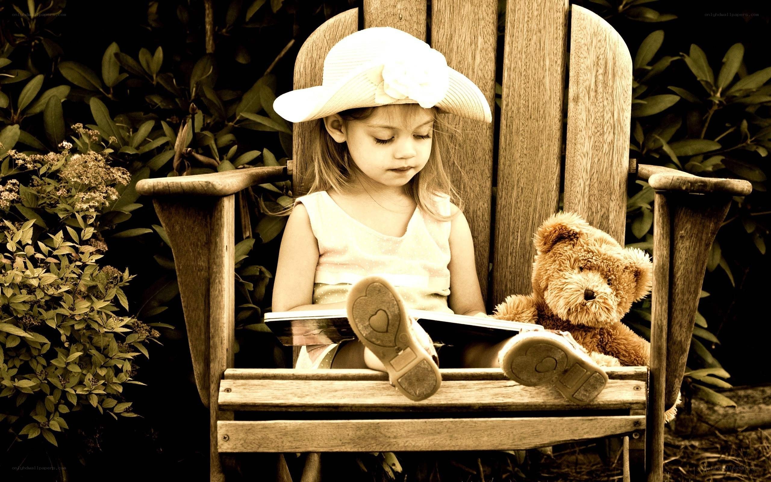 Girl reading with teddy bear