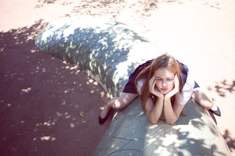 Girl resting on a sculpture