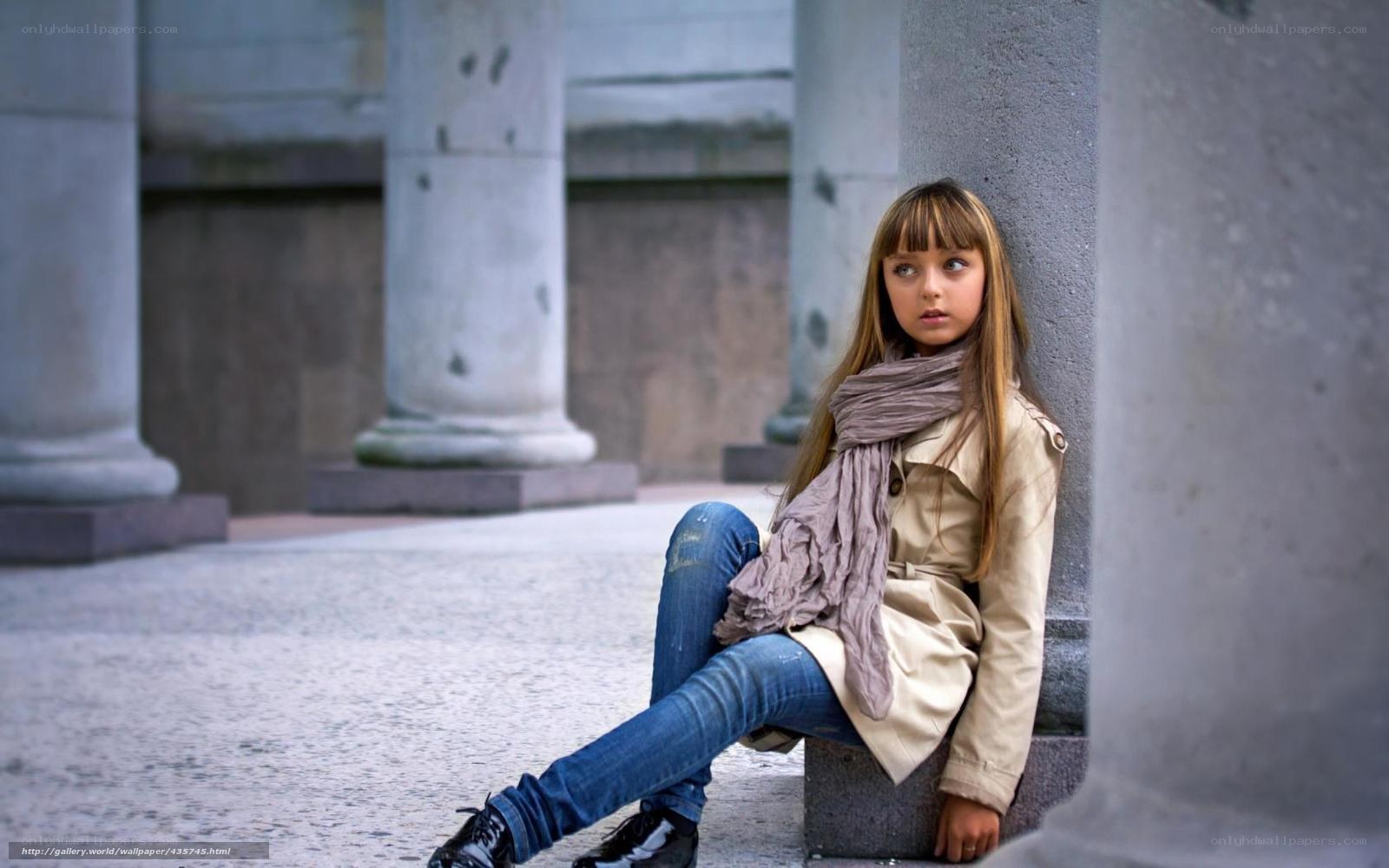 Girl sitting by a pillar