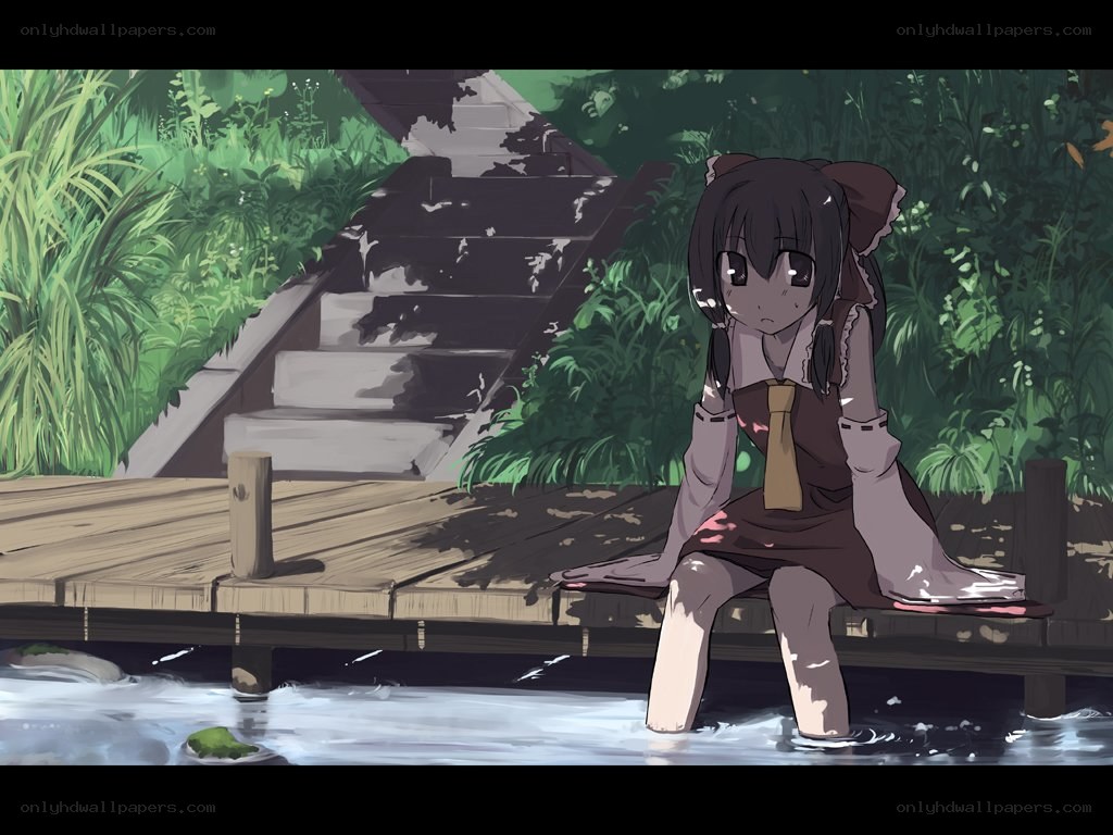 girl sitting by a pond