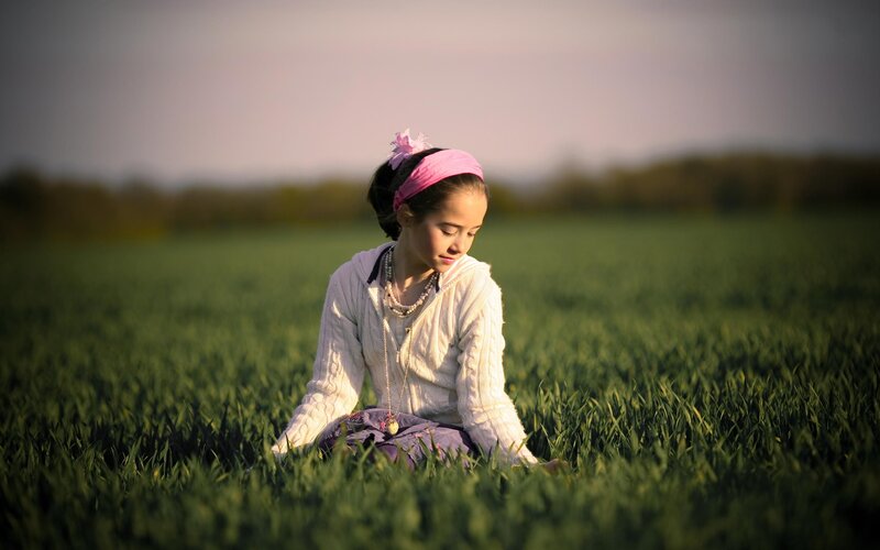 girl sitting in a green field