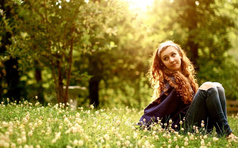 Girl sitting in a sunlit field